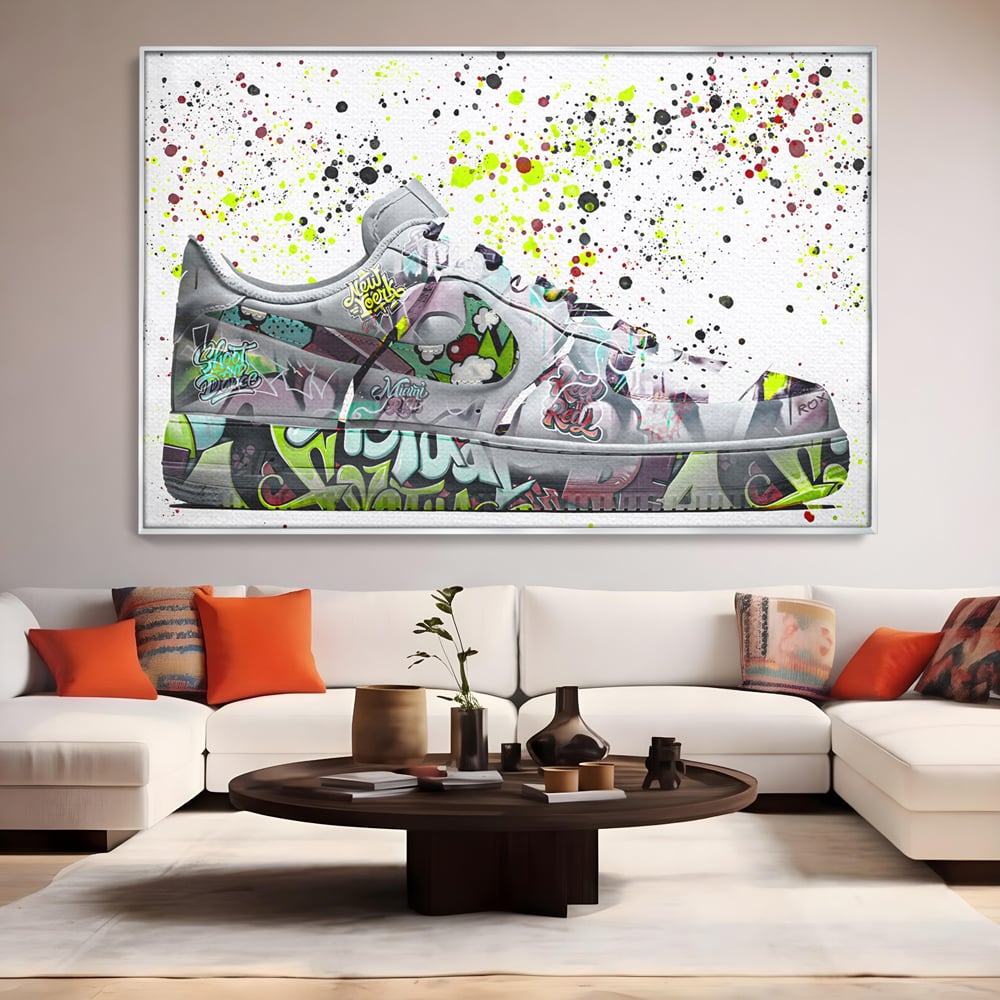 Tablou canvas cu tablou canvas cu adidasi graffiti, in rama de aluminiu argintiu, pe perete intr-un living